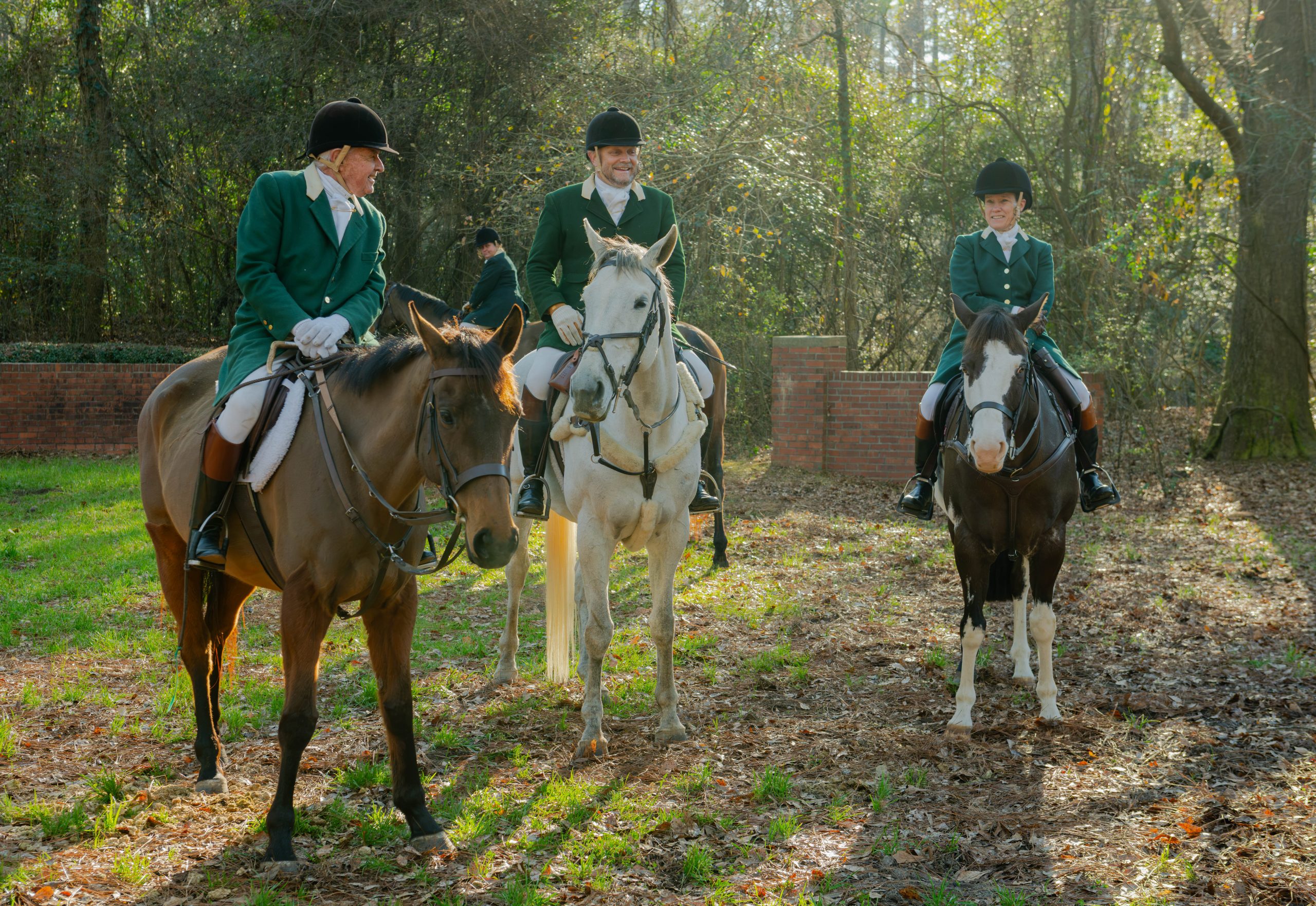 three aiken masters on horseback in green coats